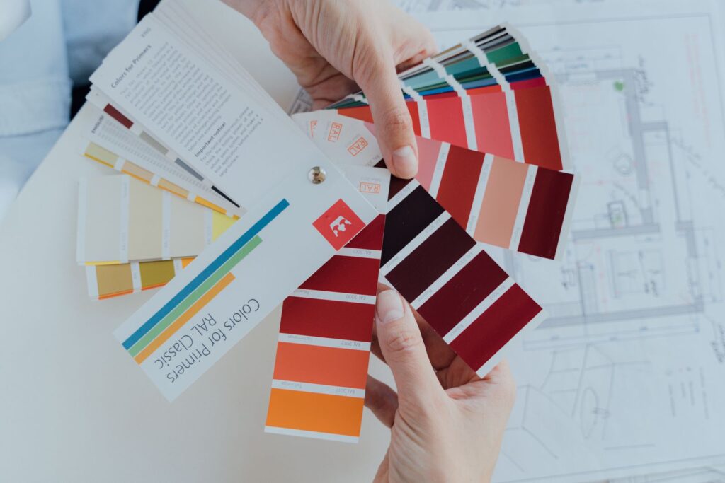Designer holding color palette swatches while choosing colors that make a design pop