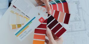 Designer holding color palette swatches while choosing colors that make a design pop